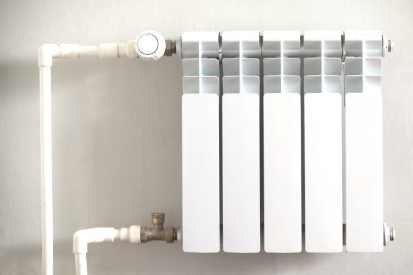Heating plumbing battery. Aluminum bimetallic radiator on a white wall close up